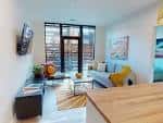Interior de un apartamento tipo co-living en Gravity Apartments, con sala de estar contemporánea y grandes ventanales