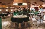 Interior del restaurante NORD con mesas redondas y lámparas colgantes