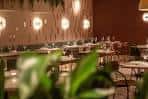 Vista interior del restaurante con iluminación cálida y plantas decorativas