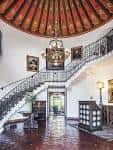 Interior del vestíbulo principal con escalera curva y techo decorado