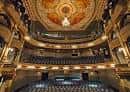 Interior del auditorio con cúpula decorada, arañas de cristal y balcones circulares