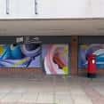 Fachada de AALFY con murales de arte urbano y buzón rojo