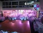 Interior del salón de eventos con mesas decoradas y luces de ambiente