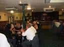 Interior del bar con clientes sentados en mesas y barra al fondo