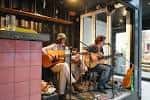 Músicos tocando guitarra en el interior del local Commune