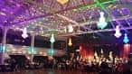 Evento en el interior del ballroom con iluminación de colores y público