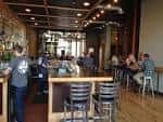 Interior del bar con clientes sentados en mesas y barra