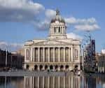 Nottingham Council House reflejado en el agua de la fuente frente al edificio, con nubes en el cielo