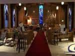 Interior del salón principal con alfombra roja y vitrales decorativos