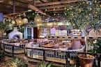 Interior de un espacio con decoración rústica y plantas, posiblemente restaurante o zona de eventos