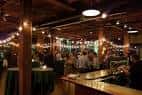 Barra principal del Schlafly Tap Room con iluminación cálida y clientes