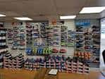 Interior de la tienda con estanterías llenas de calzado deportivo