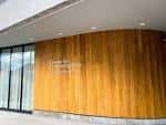 Detalle de la entrada principal con revestimiento de madera y cristal