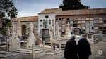 Paseo interior del cementerio con mausoleos y dos personas caminando