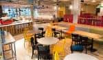 Interior del Levels Café and Lounge con mesas y sillas de colores
