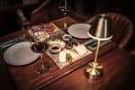 Mesa de restaurante con vajilla y copas dispuestas para una cena