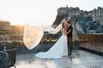 Pareja en ceremonia de boda en terraza con vista al castillo