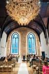 Salón principal decorado para evento con arcos góticos y gran candelabro