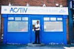 Entrada principal de Activ Physiotherapy con letrero azul y persona en la puerta