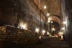 Interior del Kingsway Tunnel con arcos de ladrillo y luces colgantes