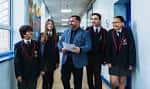 Interior de un pasillo escolar con estudiantes y personal educativo