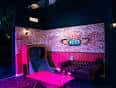 Interior del local con iluminación de neón y zona de juegos