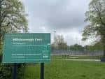 Señal informativa de entrada a Hillsborough Park con vista al campo deportivo