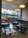 Interior del café KILN con mesas y grandes ventanales