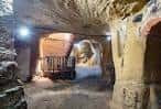Interior de una cueva iluminada con arcos de piedra y pasillos excavados