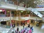 Interior del centro comercial mostrando múltiples niveles y escaleras mecánicas