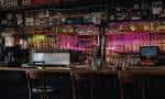 Interior del taproom de Liquid Light Brewing Company con decoración colorida y mesas