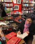 Interior de la librería Typewronger Books con una persona firmando libros