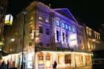 Fachada exterior del teatro iluminado por la noche