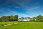 Fachada del club house del West Derby Golf Club con césped bien cuidado