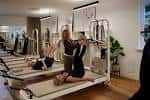 Clase de Pilates en curso dentro del estudio, mostrando el espacio y equipamiento