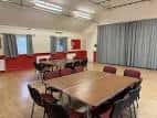 Sala interior del centro comunitario St Ninian's Comely Bank con mesas y sillas