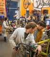Interior del taller de bicicletas con personas trabajando en reparaciones