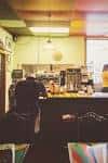 Área interior del café con clientes y mostrador de servicio
