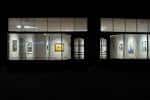 Vista nocturna de la fachada iluminada de Weinstein Hammons Gallery con obras expuestas en las ventanas
