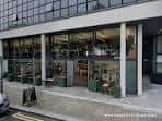 Fachada moderna de Lovelocks Coffee Shop con grandes ventanales y columnas blancas