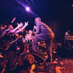 Cantante interactuando con el público desde el borde del escenario