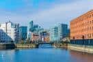 Panorámica de la zona de Queens Dock con edificios modernos y canal