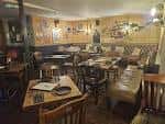 Sala de comedor con mesas dispuestas para eventos y decoración rústica
