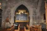 Detalle del interior con un arco gótico y un cuadro religioso enmarcado