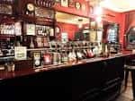 Interior del bar con estanterías de bebidas y grifos de cerveza