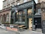 Fachada exterior de Bellfield Brewery con entrada y mesas al aire libre