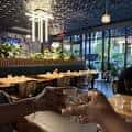 Interior del restaurante con mesas, iluminación moderna y ambiente acogedor