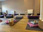Sala de yoga preparada con esterillas y cojines para eventos grupales