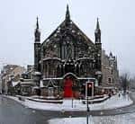 Vista exterior del Bedlam Theatre en invierno con nieve y puerta roja
