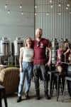 Interior de Shout Brewing con tanques de fermentación y clientes sentados